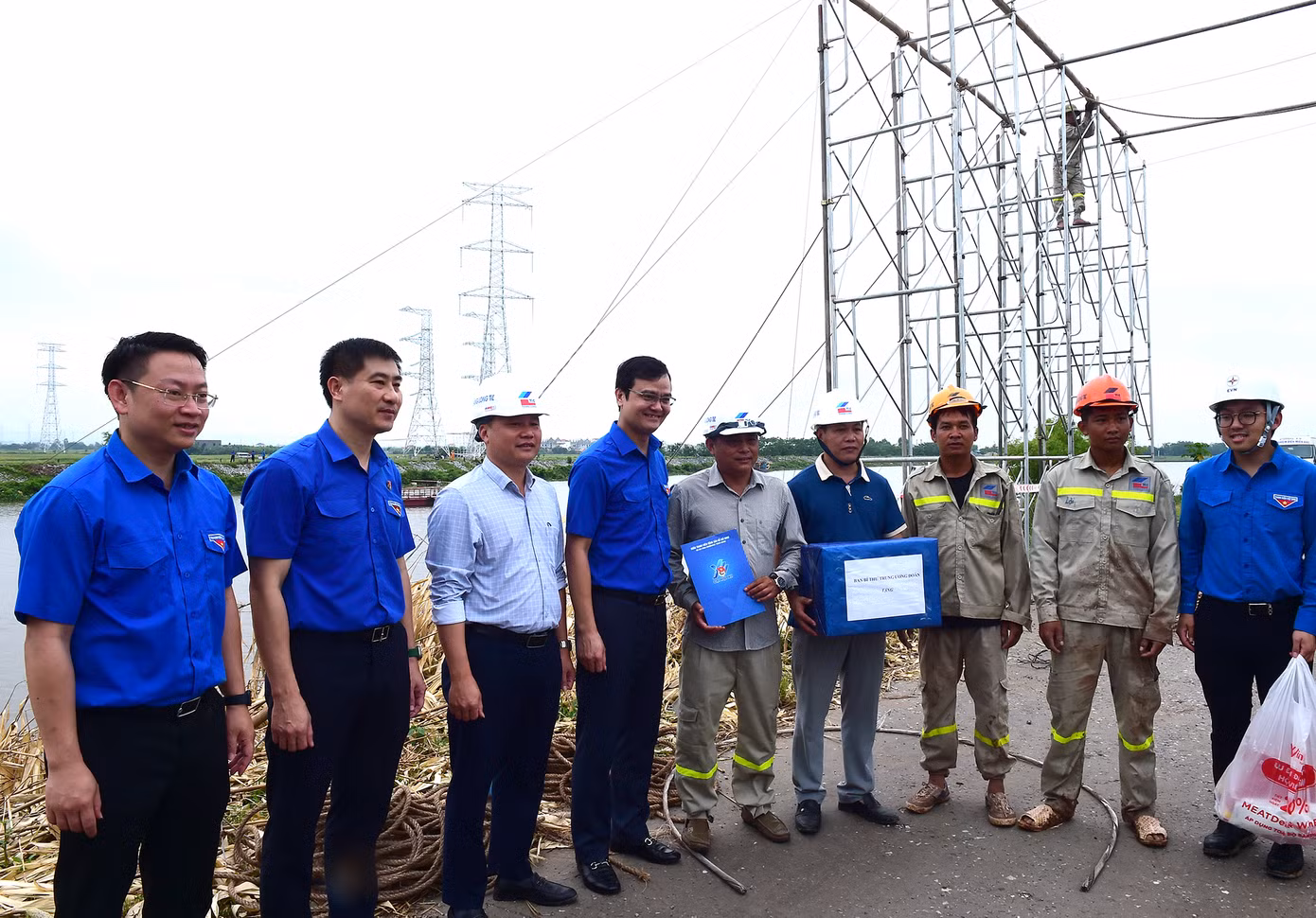 Anh Bùi Quang Huy - Bí thư thứ nhất T.Ư Đoàn (thứ 4 từ trái sang) tặng quà động viên thanh niên công nhân trực tiếp thi công công trình tại huyện Kim Sơn. Ảnh: Xuân Tùng
