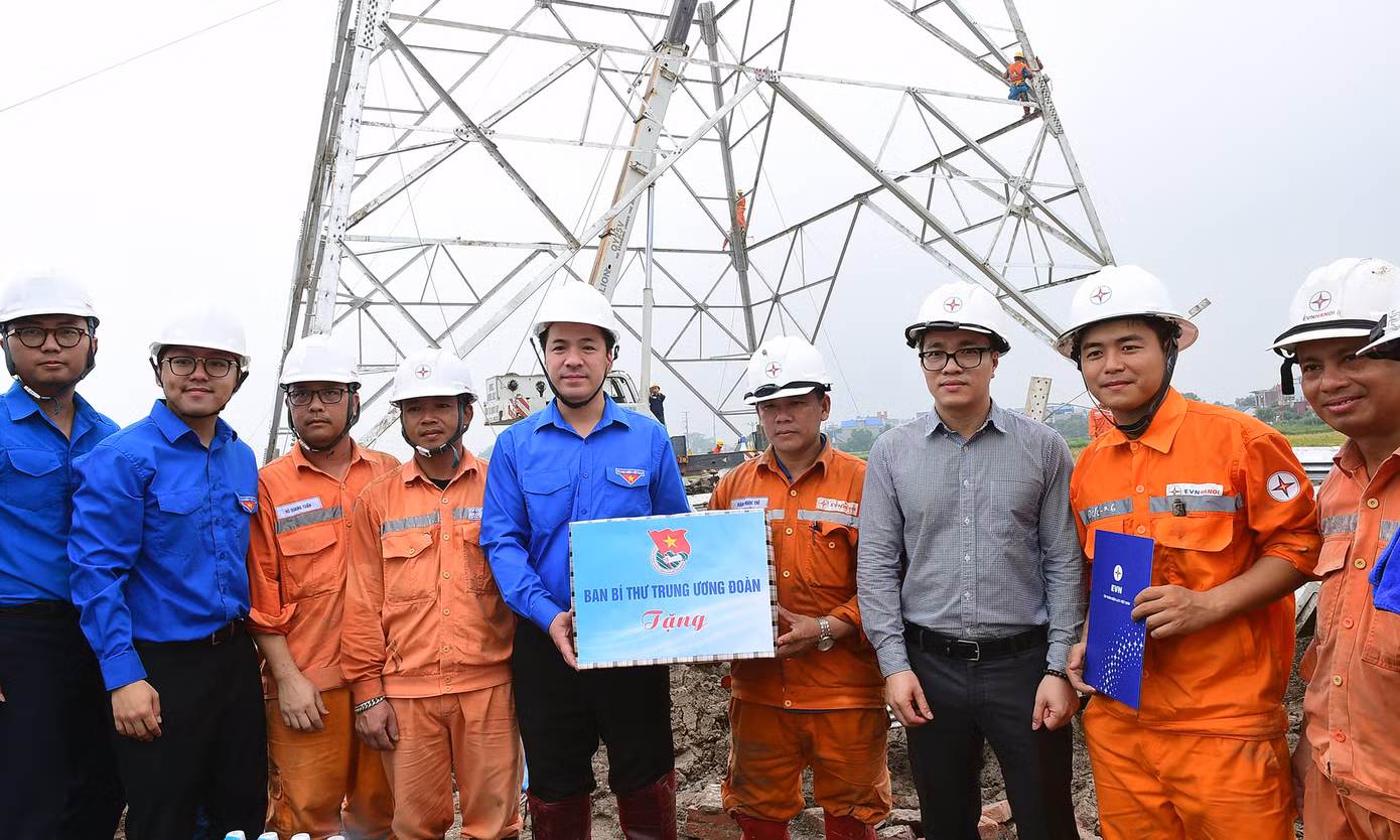 Anh Ngô Văn Cương tặng quà thanh niên công nhân thi công đường dây tại xã Hòa Phong (thị xã Mỹ Hào, Hưng Yên). Ảnh: Xuân Tùng