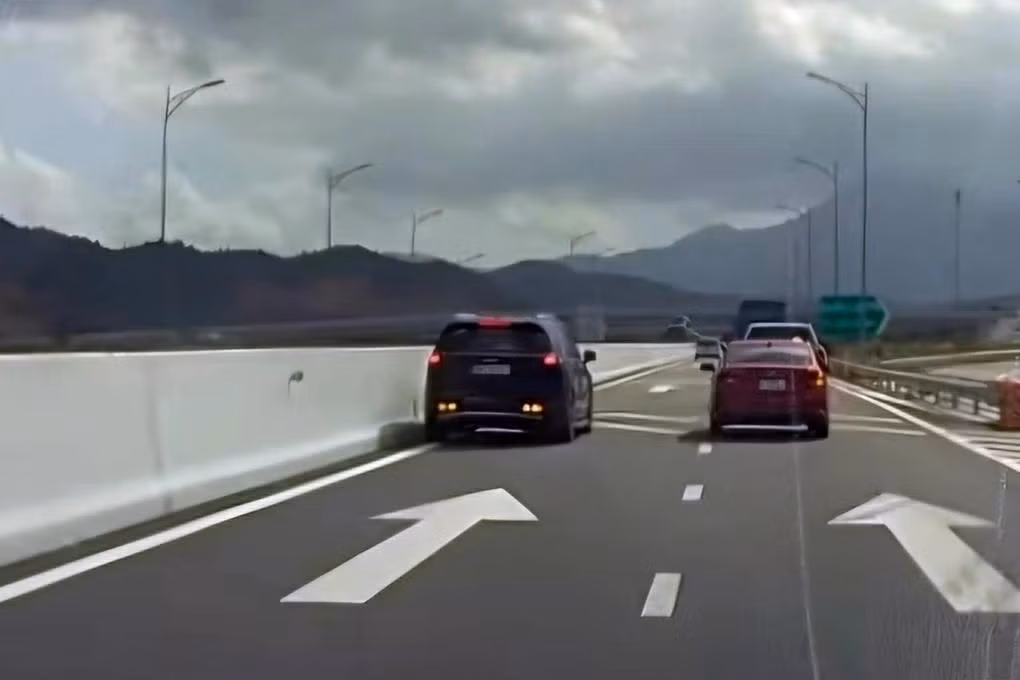 Xe ô tô 7 chỗ (màu đen, bên trái) chạy lùi trên cao tốc Nha Trang - Cam Lâm. Ảnh cắt từ clip Xe ô tô 7 chỗ (màu đen, bên trái) chạy lùi trên cao tốc Nha Trang - Cam Lâm. Ảnh cắt từ clip