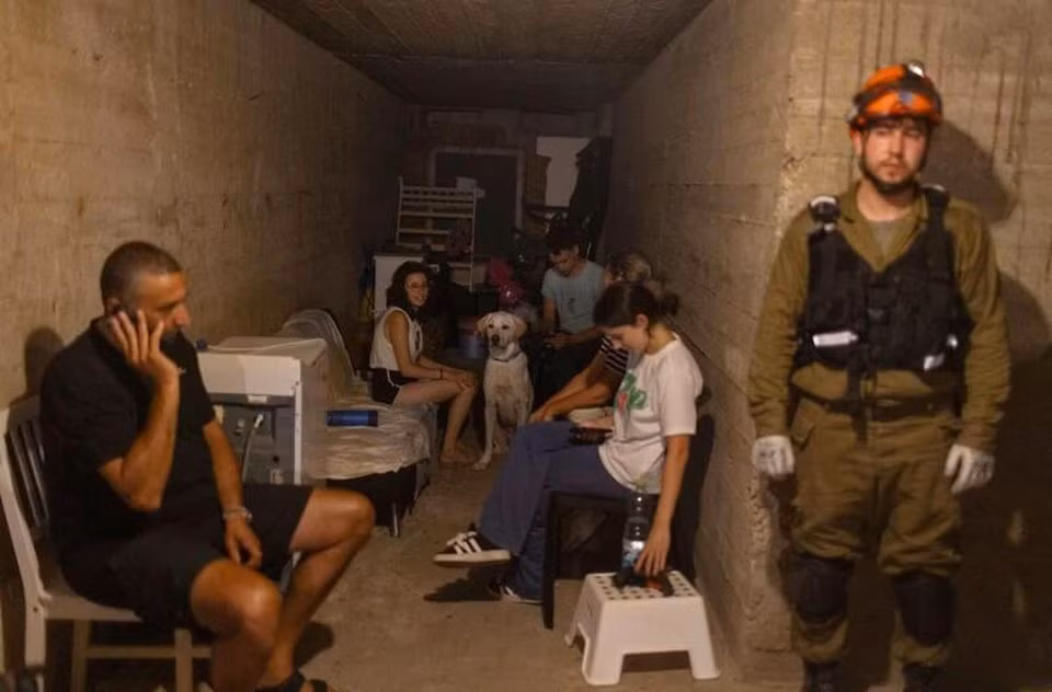 Thay vì ở trong các khách sạn đã đặt, du khách đang phải trú ẩn trong hầm tránh bom ở Bat Yam, Israel. Ảnh: Blooberg.