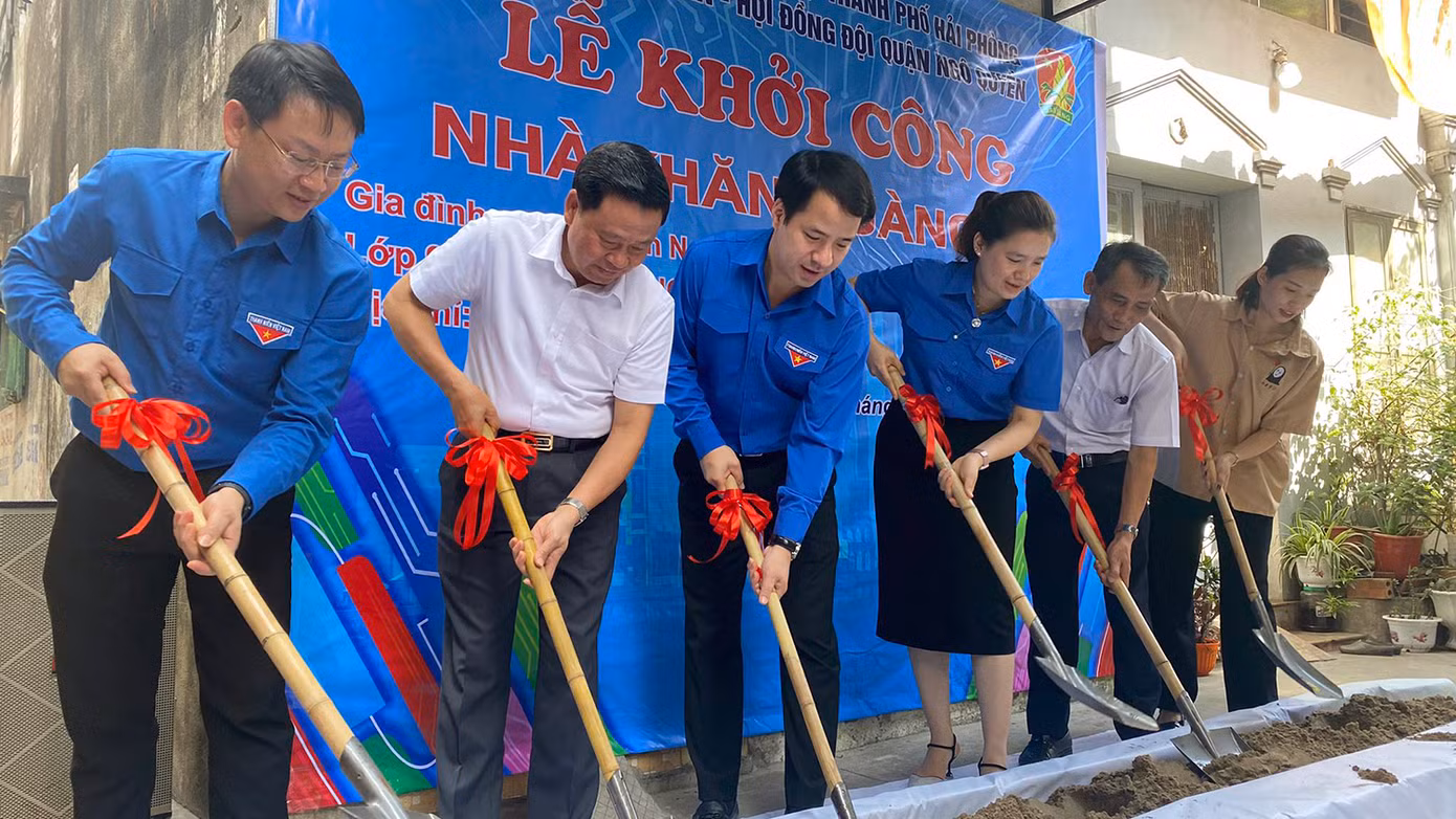 Các đại biểu và đại diện gia đình em Nguyễn Ngọc Bảo Anh thực hiện nghi lễ khởi công xây dựng nhà khăn quàng đỏ.