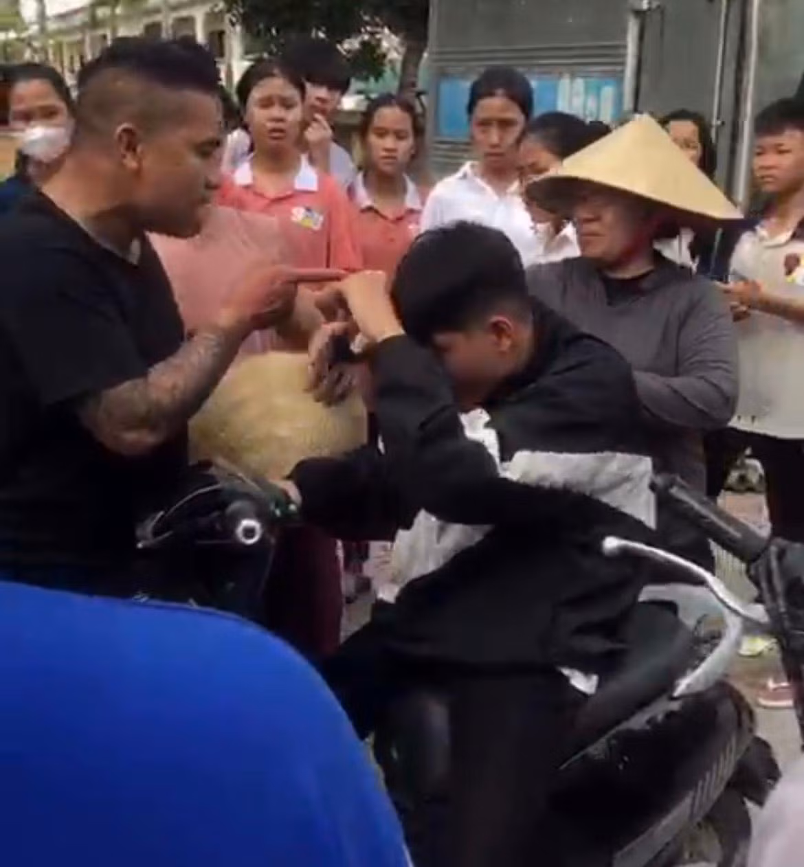 Người đàn ông đánh học sinh trước sự chứng kiến của nhiều người. Ảnh cắt từ video