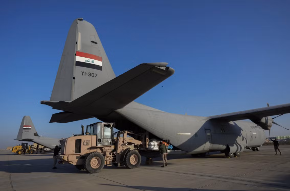 Lực lượng an ninh Iraq dỡ hàng viện trợ nhân đạo tại sân bay quân sự gần Baghdad, ngày 24/1. (Ảnh: AP)