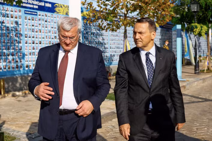 Ngoại trưởng Ba Lan Radoslaw Sikorski và người đồng cấp Ukraine Andrii Sybiha thăm Bức tường tưởng niệm những người bảo vệ Ukraine đã ngã xuống bên ngoài Nhà thờ Saint Michael, ngày 13/9. (Ảnh: Reuters)