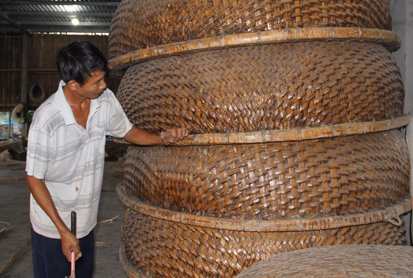 Để làng nghề truyền thống đan thúng chai Phú Mỹ tiếp tục phát triển và mang lại nguồn thu nhập cho người dân, UBND xã An Dân đã vận động bà con thành lập nhóm, tổ hợp sản xuất để đẩy nhanh việc thành lập thương hiệu sản phẩm và có chính sách hỗ trợ bà con làm nghề mở rộng, phát triển sản xuất. Trong ảnh, người dân kiểm tra chất lượng thúng chai trước khi xuất xưởng.