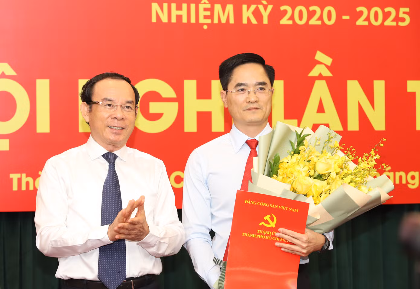 Bí thư Thành ủy TPHCM Nguyễn Văn Nên trao quyết định và hoa chúc mừng ông Trần Quang Lâm. Ảnh: Ngô Tùng