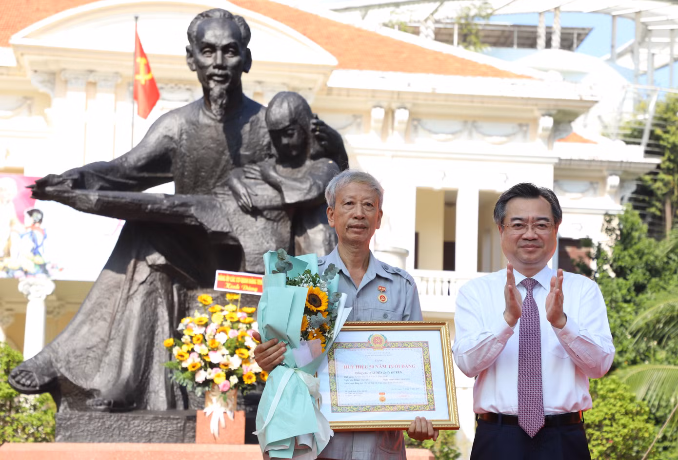 Phó Bí thư Thường trực Thành ủy TPHCM trao Huy hiệu 50 năm tuổi Đảng đến đảng viên Nguyễn Dân Quyền. Ảnh: Ngô Tùng