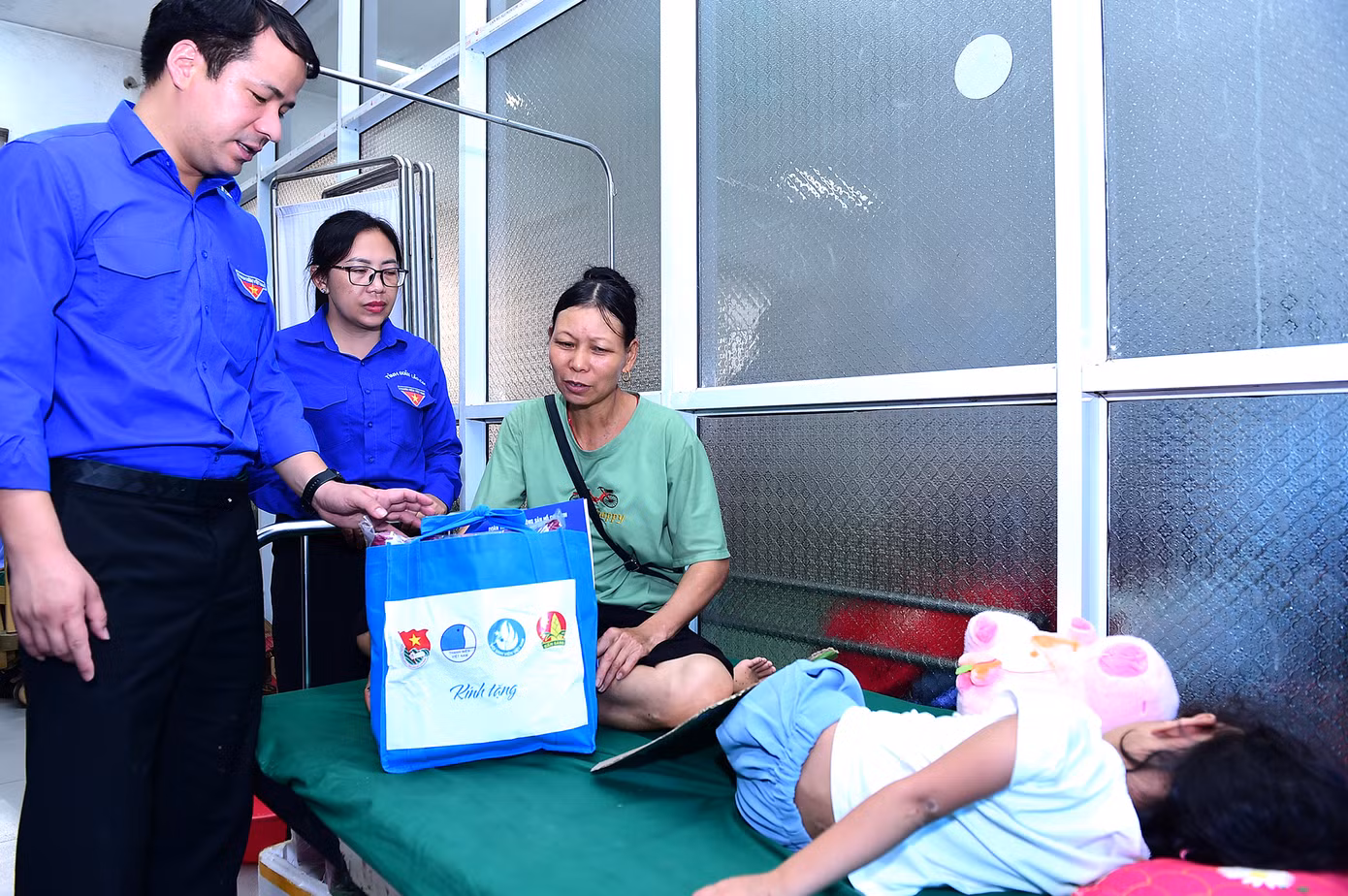 Anh Ngô Văn Cương tặng quà, động viên thanh thiếu niên bị thương trong lũ quét ở thôn Làng Nủ đang điều trị tại bệnh viện đa khoa huyện Bảo Yên. Ảnh: Xuân Tùng