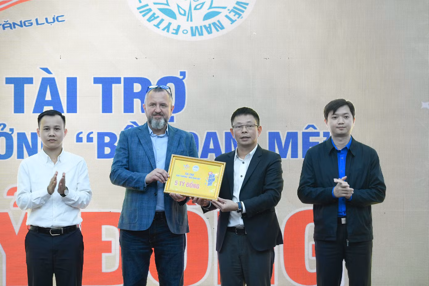 Ông Andrzej Tomasz Bialasiewicz trao biểu trưng tài trợ 5 tỷ đồng cho nhà báo Phùng Công Sưởng - Tổng Biên tập Báo Tiền Phong, Giám đốc Trung tâm Quỹ Hỗ trợ Tài năng trẻ Việt Nam.