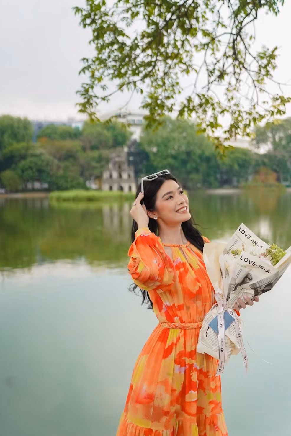 Miss Indonesia 2020 nổi bật trong thiết kế tông màu vàng cam của nhà thiết kế Lê Thanh Hòa tại Hồ Gươm.