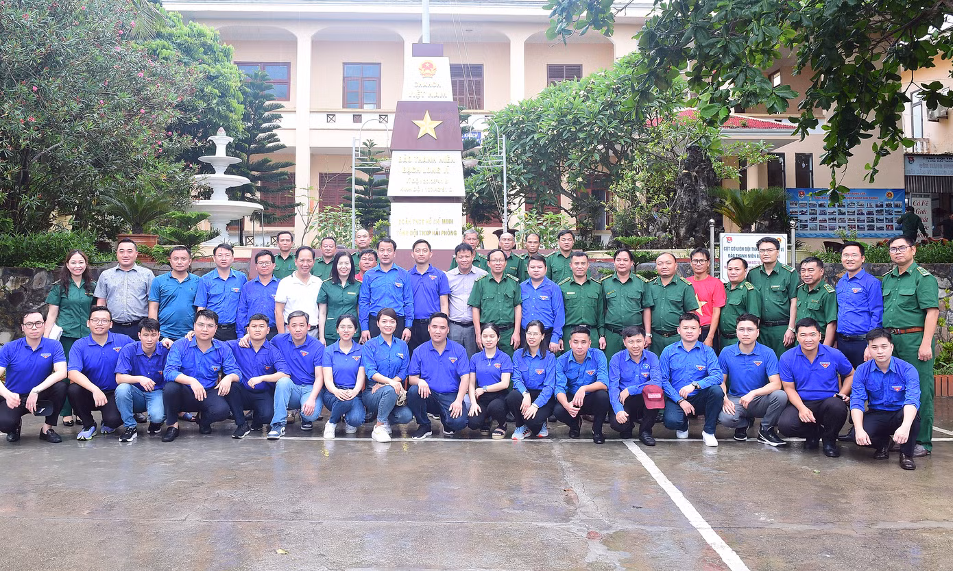 Các đại biểu chụp ảnh lưu niệm bên Cột cờ TNXP Bạch Long Vĩ. Ảnh: Xuân Tùng