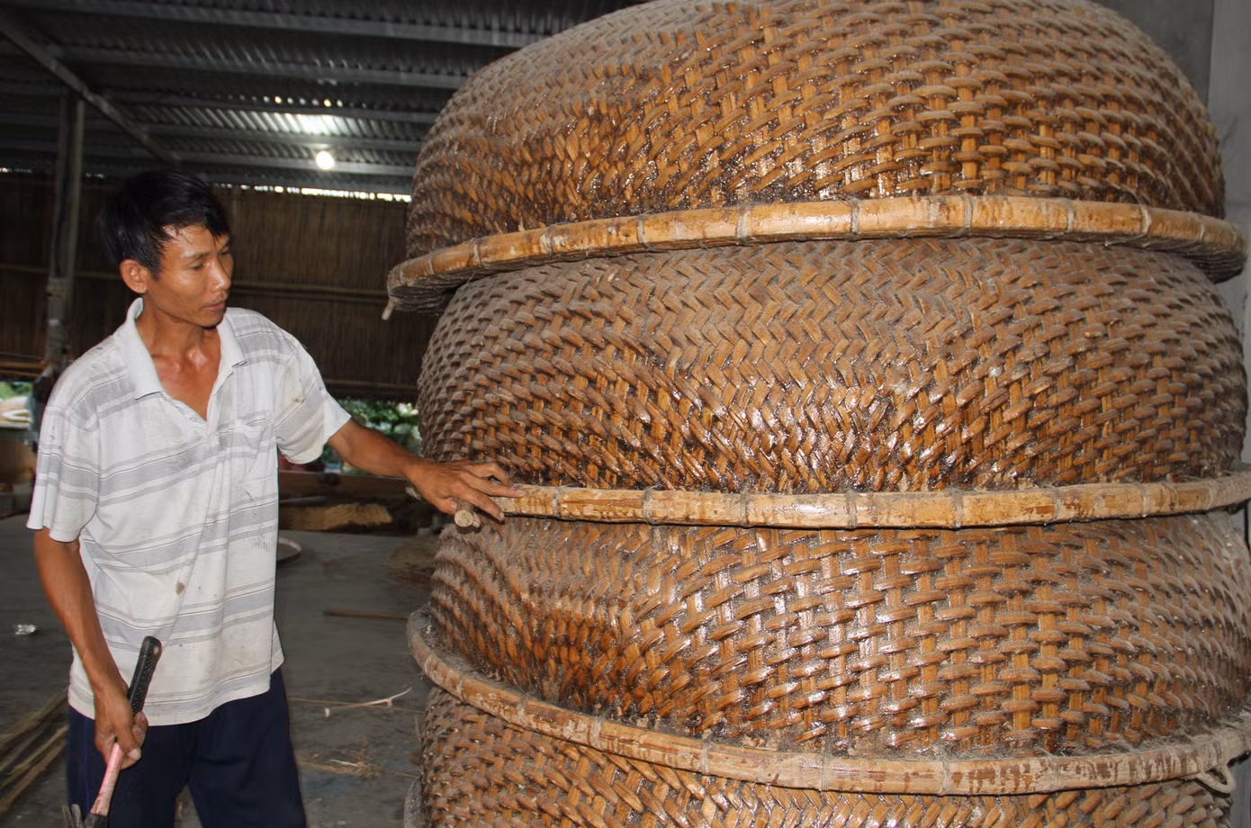Ông Trương Văn Trung tỉ mỉ nắn lại vành thúng chai trước khi đem bán. Ảnh: Công Hoan