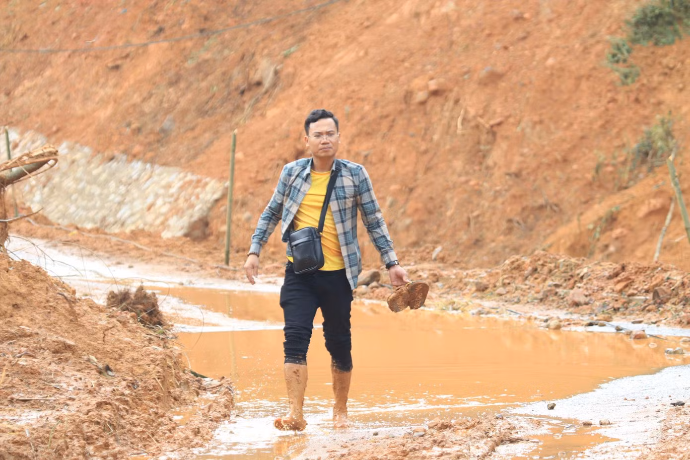 Phóng viên Cảnh Huệ lội bùn tác nghiệp tại hiện trường vụ sạt lở.