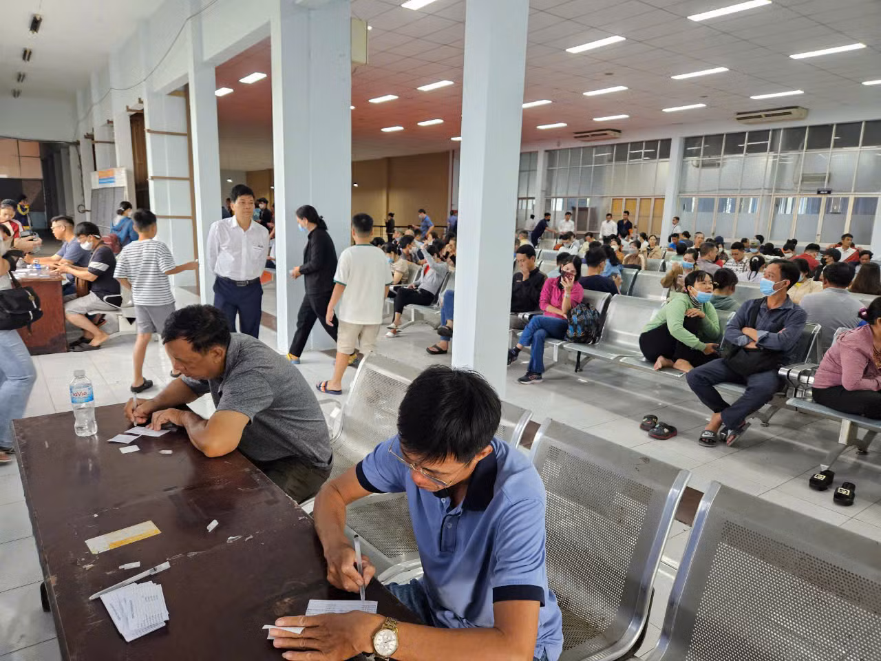 Người dân điền phiếu thông tin trước khi mua vé. Người dân điền phiếu thông tin trước khi mua vé.