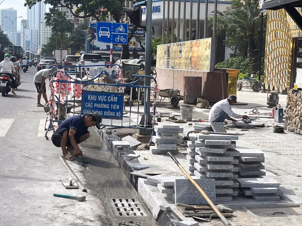 Công nhân Công ty Dũng Lợi thi công xây dựng các công trình nâng cấp, cải tạo vỉa hè phía Đông, phía Tây và giải phân cách đường Trần Phú. Ảnh: Lữ Hồ.