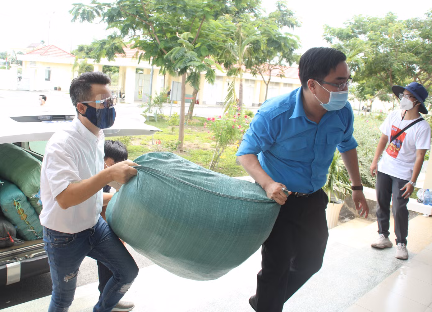 Sau phần biểu diễn của mình, ca sỹ Hoàng Bách cùng anh Ngô Minh Hải, Chủ tịch Hội Liên hiệp thanh niên Việt Nam TPHCM vận chuyển trang thiết bị gửi tặng đến các y bác sỹ tuyến đầu chống dịch