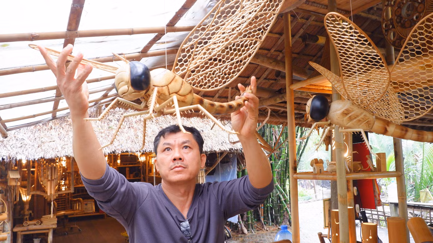 Anh Võ Tấn Tân cùng một sản phẩm được làm ra từ chất liệu tre dân dã