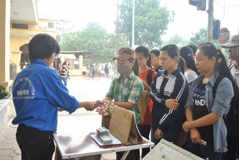 Phát phiếu mua cơm cho các bạn sinh viên 