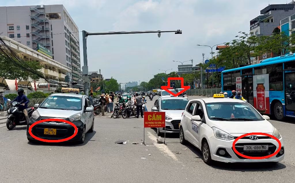 Nguyên nhân ùn tắc do có nhiều xe taxi dừng đỗ, chờ đón khách trên đường đoạn trước cổng bệnh viện Bạch Mai. Các xe này trên biển số đều bị làm mờ ít nhất từ một đến hai chữ số.