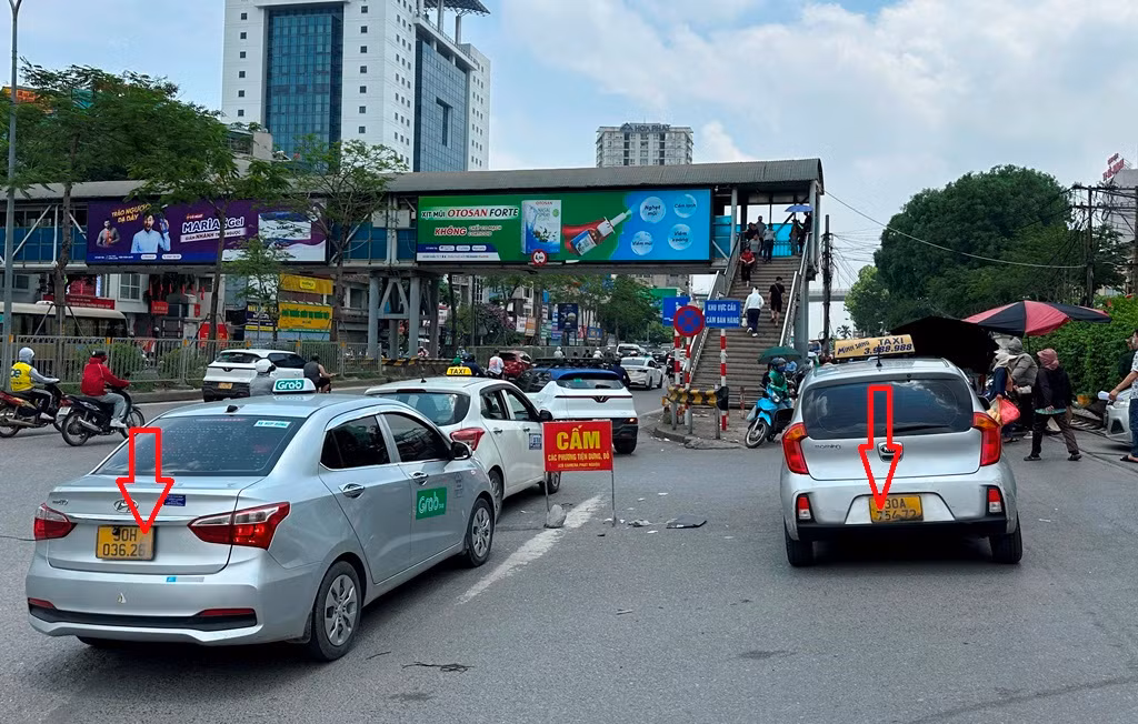 Hàng loạt taxi đeo biển taxi truyền thống (taxi hãng) và taxi công nghệ (chạy grab) đều che biển khi đứng bắt khách "chợ" (khách vẫy xe trên đường) trước cổng bệnh viện Bạch Mai.