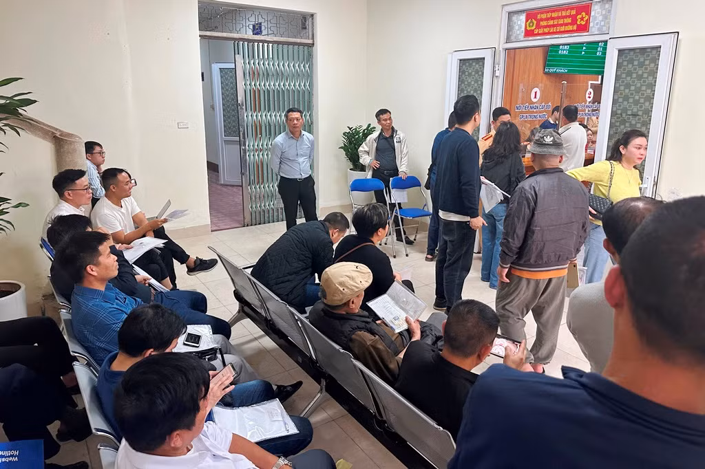 Người dân ngồi chờ đợi được làm thủ tục cấp đổi GPLX tại điểm Hà Đông chiều 3/3. Ảnh: T.Đảng