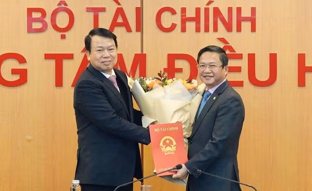 Thứ trưởng Bộ Tài chính Nguyễn Đức Chi trao quyết định và chúc mừng đồng chí Phạm Chí Thanh.