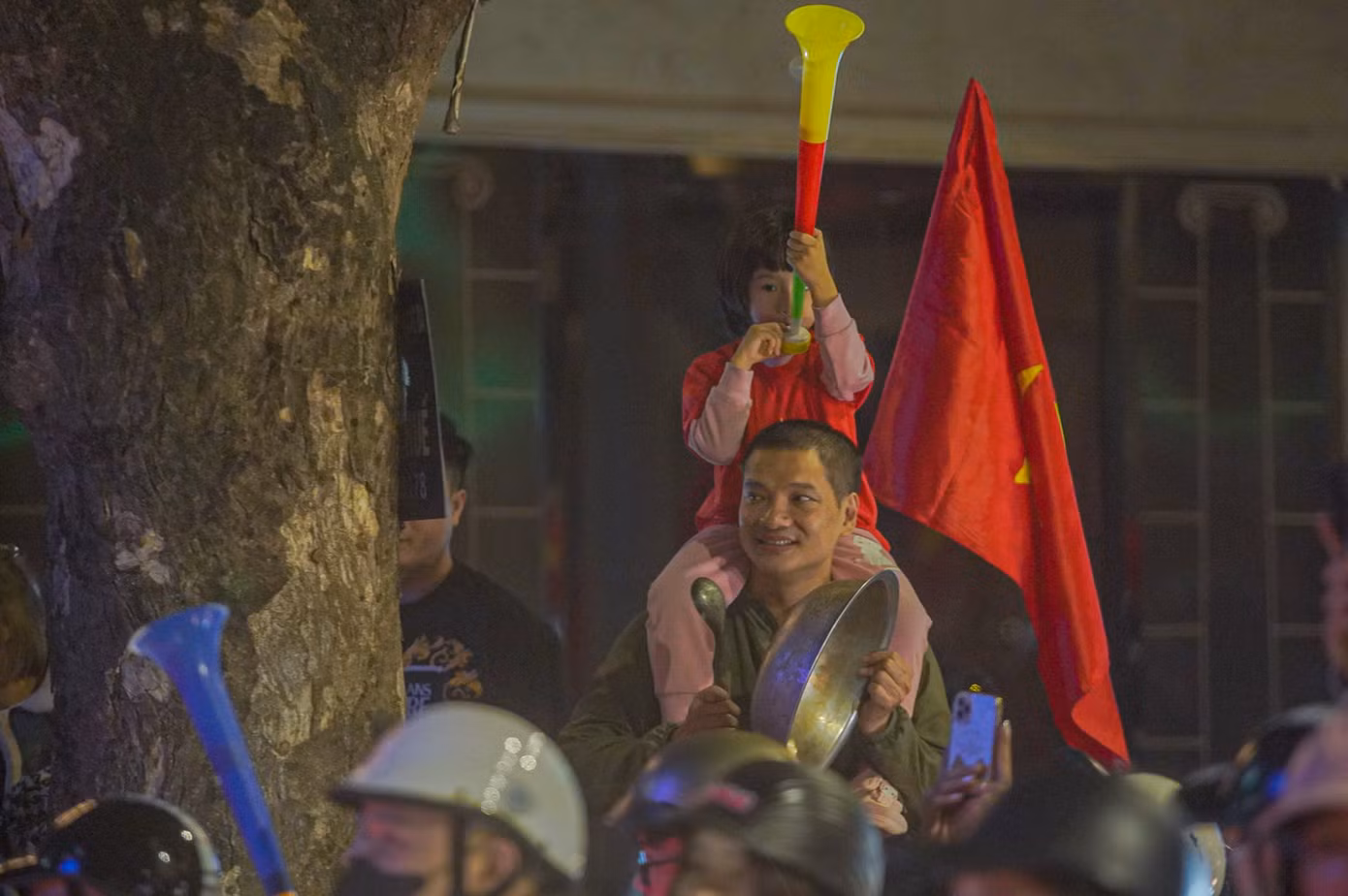 Một cổ động viên cầm muôi và chậu ra đường ăn mừng chiến thắng.