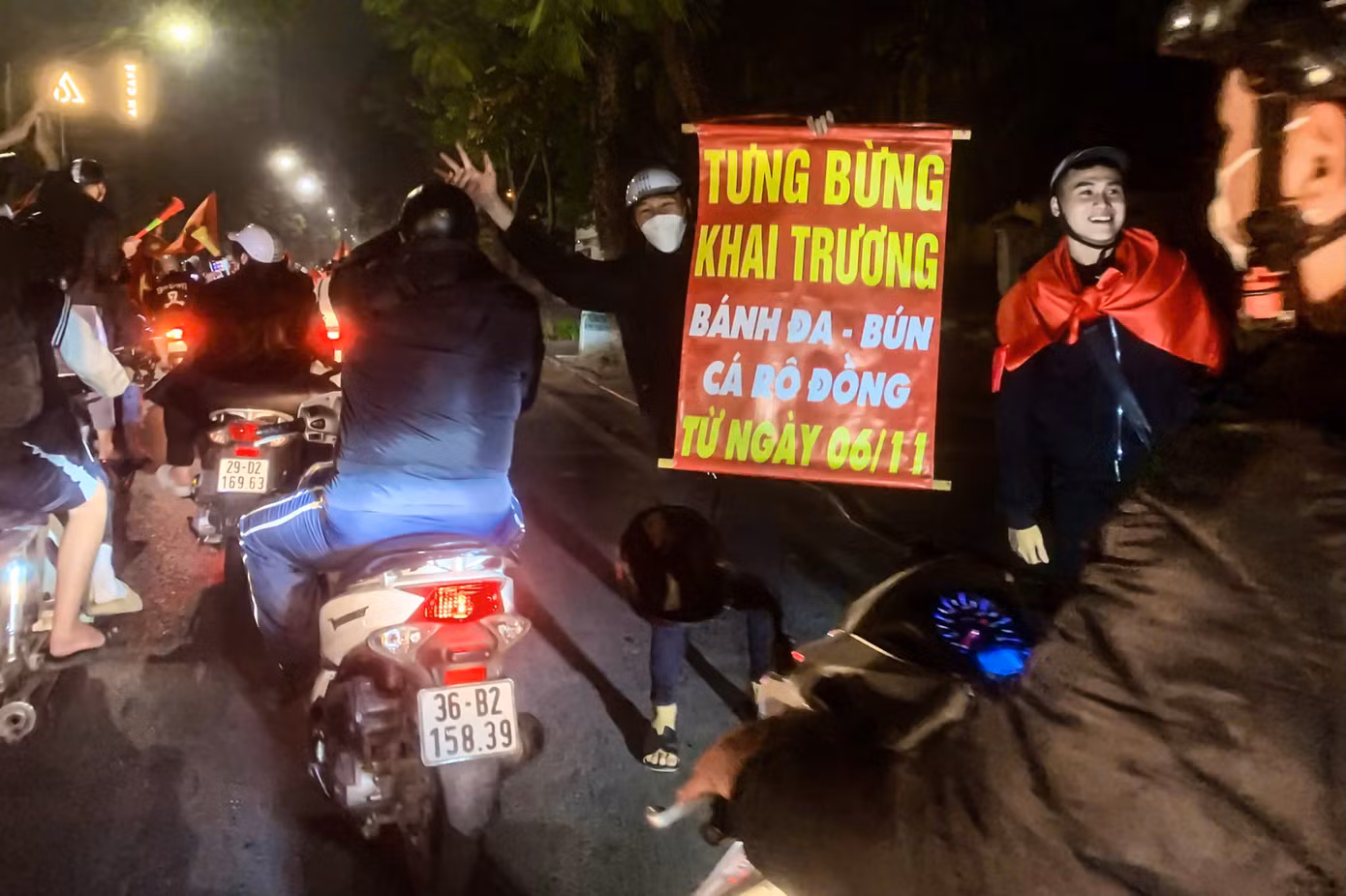 Người hâm mộ mang biển khai trương ra đường quảng cáo với dòng phương tiện.