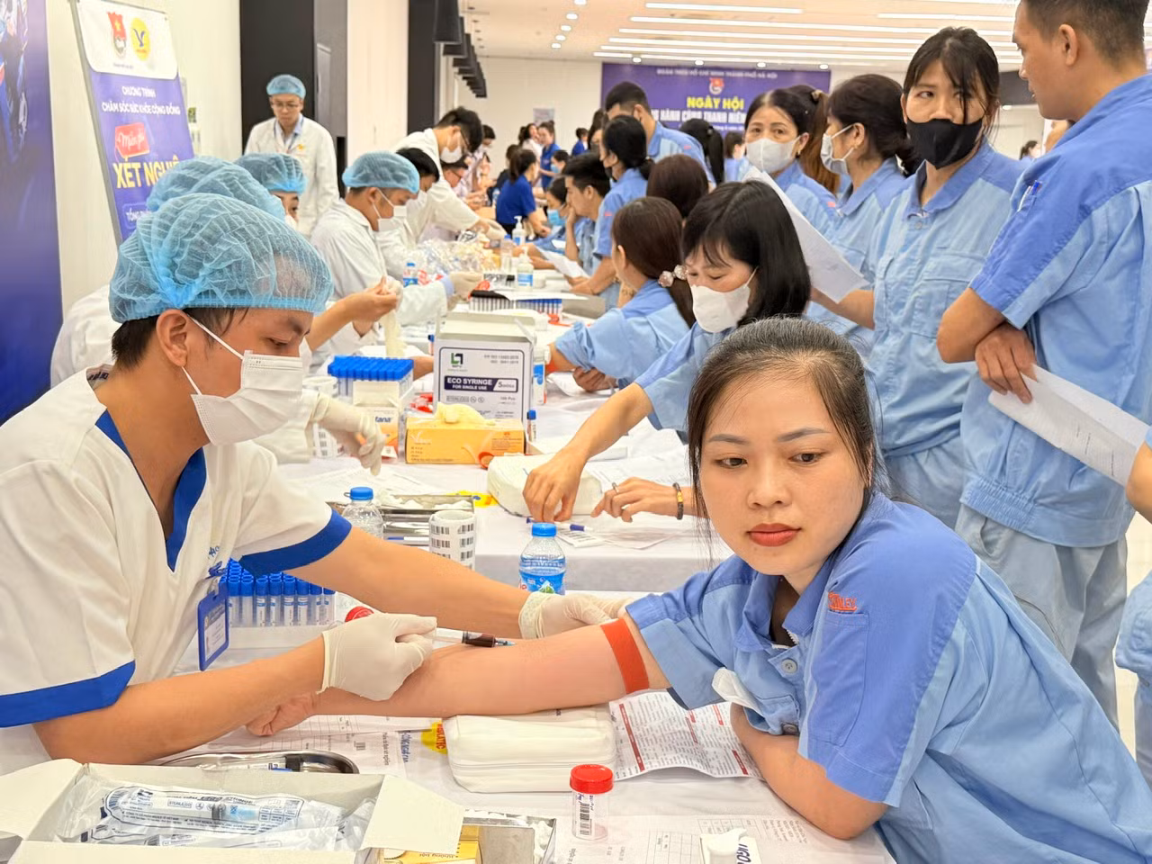 Đội ngũ y, bác sĩ lấy máu xét nghiệm cho thanh niên công nhân