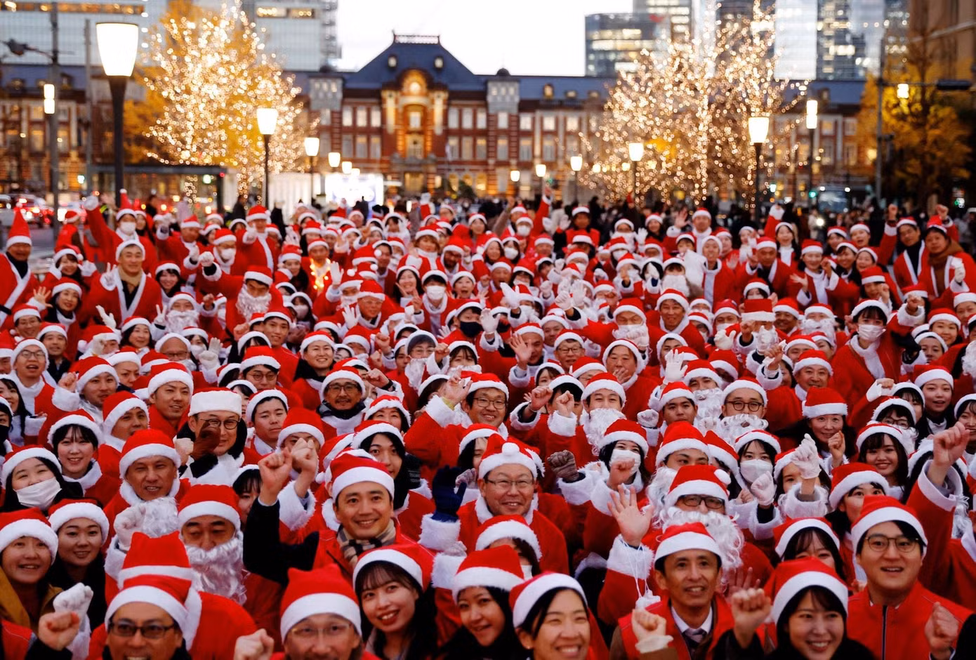 Người dân mặc trang phục Ông già Noel chụp ảnh trước sự kiện phát quà và dọn dẹp đường phố mừng Giáng sinh ở Tokyo (Nhật Bản). Ảnh: Reuters