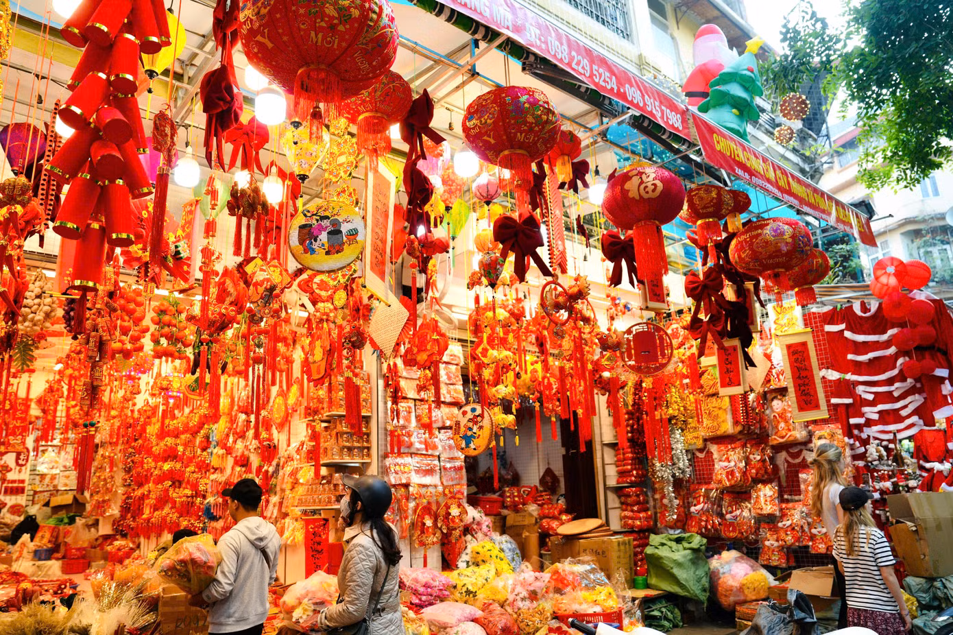 Các cửa hàng bày bán đa dạng đồ trang trí Tết như cành đào, pháo dây, bao lì xì, đèn lồng, câu đối...