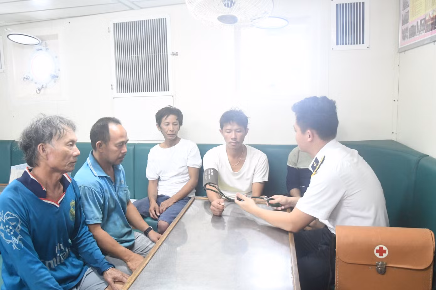 Các bác sĩ Tàu 471 kiểm tra sức khoẻ cho 5 ngư dân Bình Định gặp nạn. Ảnh: Nguyễn Nam.