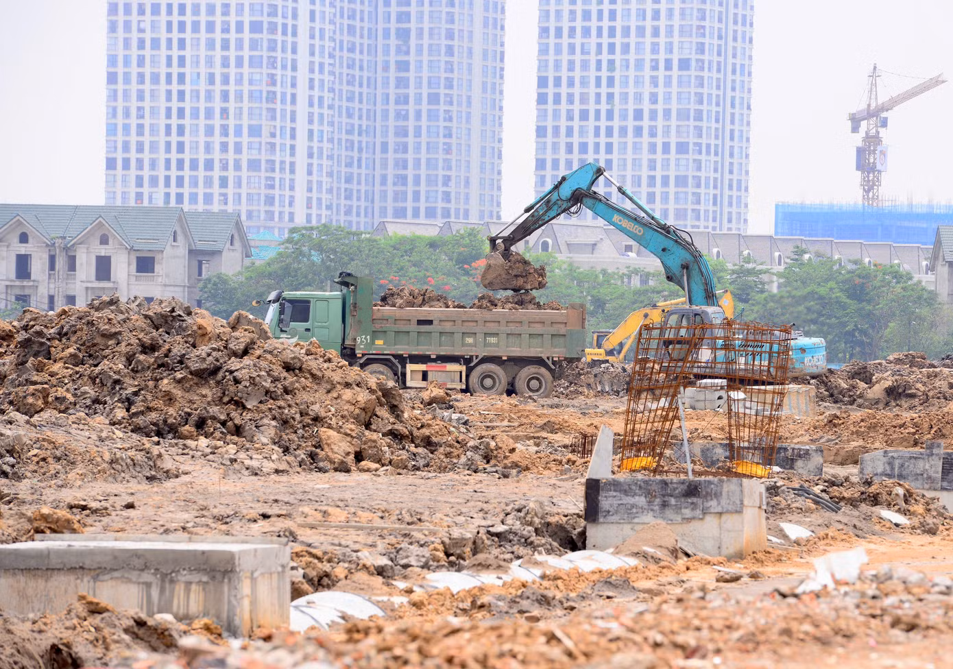 Trên công trường, các khu đất đang được san nền, bóc tách và tạo hình mặt bằng, chuẩn bị cho hệ thống đường nội bộ và các tiện ích mặt nước.