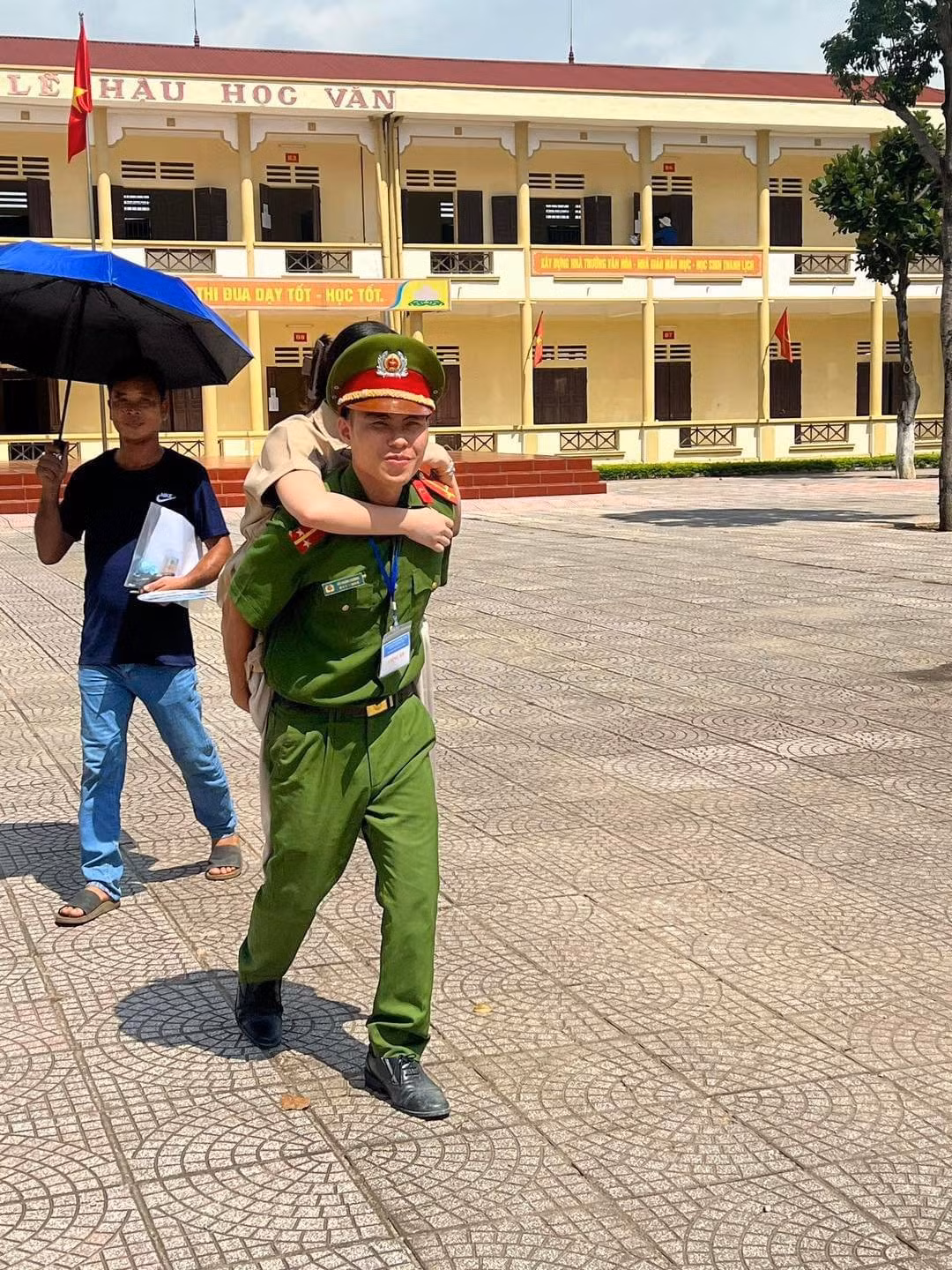 Trung úy Vũ Mạnh Cường cõng nữ sinh lớp 12 Nguyễn Thị Hồng Linh tham gia kỳ thi tốt nghiệp tại điểm thi Trường THPT Trung Nghĩa.