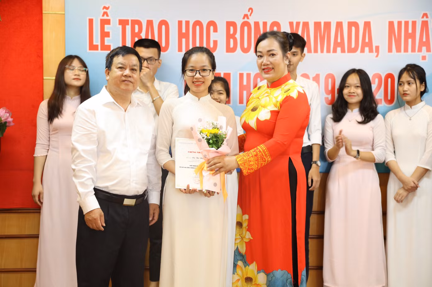 Vũ Thị Ngần, đứng giữa nhận hoa, trong một lần được trao học bổng