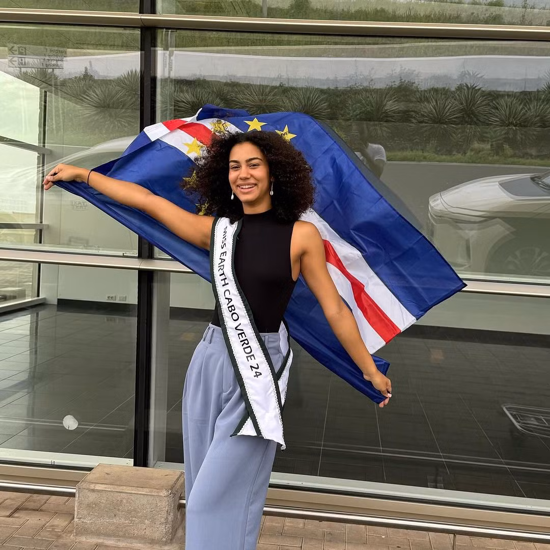 Đại diện Cabo Verde - Jasmine Jorgensen - để mặt mộc ra sân bay. Cô năm nay 19 tuổi, là sinh viên chuyên ngành kinh doanh. Thông qua công việc của mình, Jasmine hướng đến mục tiêu đề cao môi trường tự nhiên trong các chiến lược cho sức khỏe tinh thần và thúc đẩy các hoạt động bền vững.