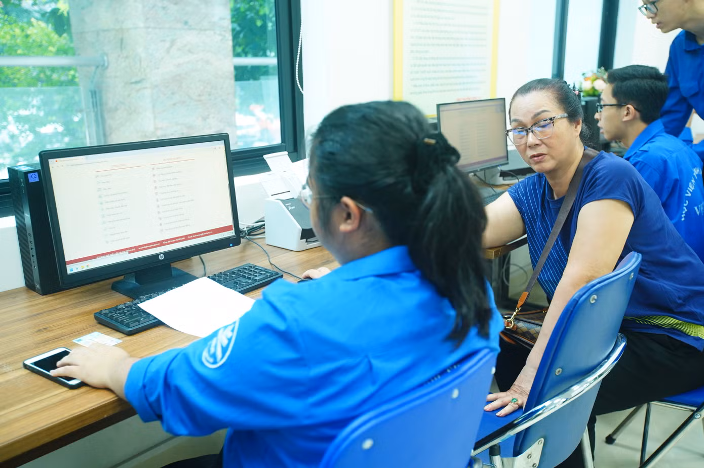 Tình nguyện viên "trực chiến" bên khu vực máy tính, giúp người dân kê khai online, nhập dữ liệu nhanh chóng. Ảnh: Duy Phạm