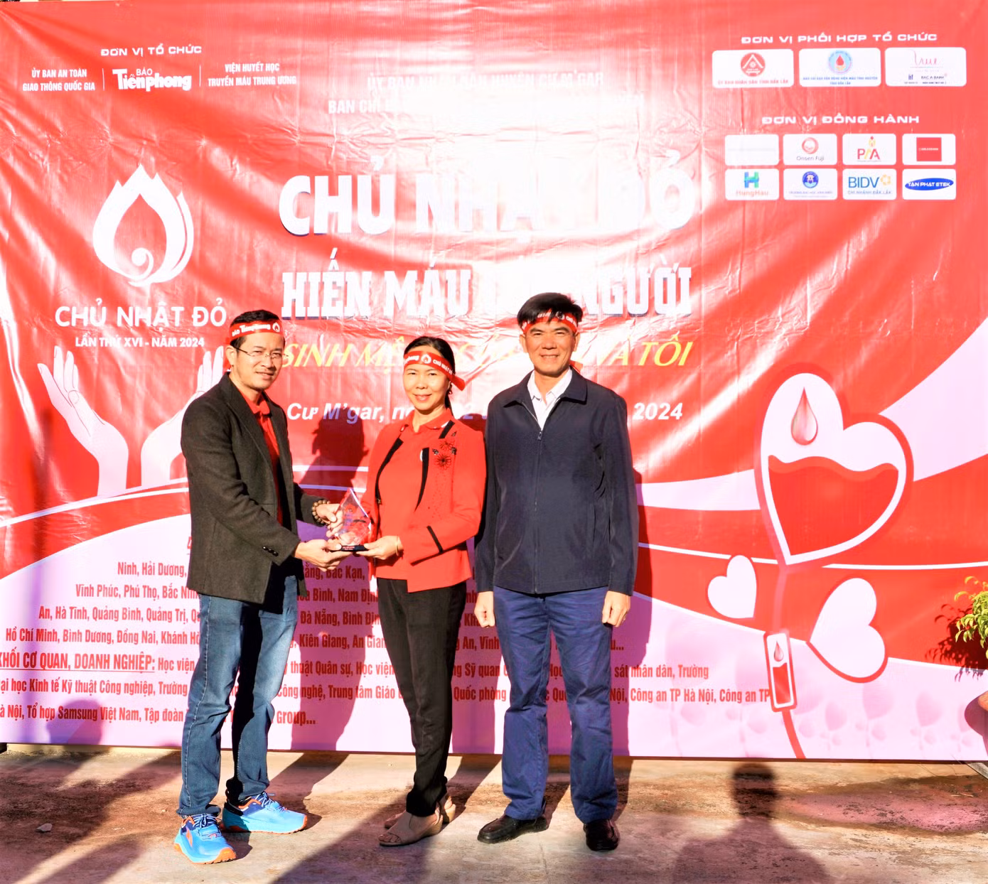 Ông Nguyễn Công Văn - Phó Chủ tịch UBND huyện Cư M'gar (phải) cùng đại diện Hội Chữ thập Đỏ huyện, nhận Kỷ niệm chương từ Ban tổ chức