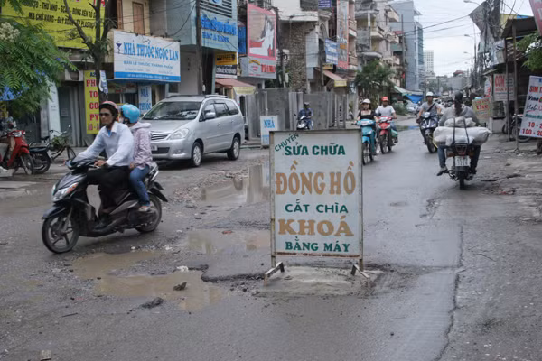 Nhiều người thấy bất ngờ khi thấy Một tấm biển hiệu quảng cáo chắn giữa đường. (Tấm biển quảng cáo này để ngăn không cho phương tiện đi vào chỗ nắp cống mới xây lại)