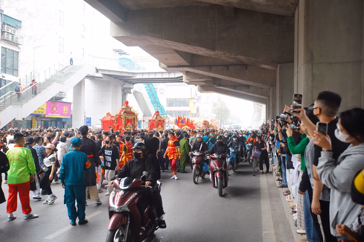 Người dân đi qua, tò mò đứng lại hai bên đường, dải phân cách để quay phim chụp ảnh đoàn rước kiệu đặc biệt này.