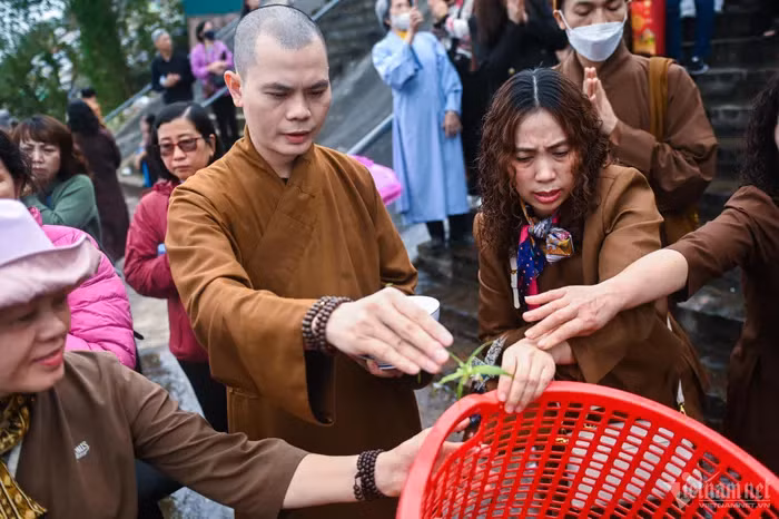 Sư thầy Thích Khải Thành đọc kinh chú trước khi thả cá xuống nước.