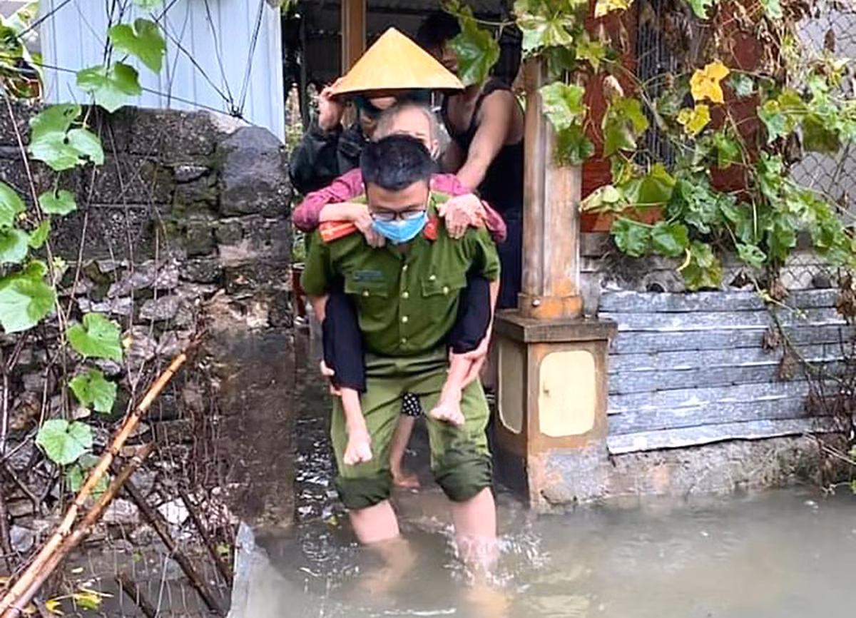 Công an huyện Quỳnh Lưu hỗ trợ các cụ già trên địa bàn di dời tránh lũ.