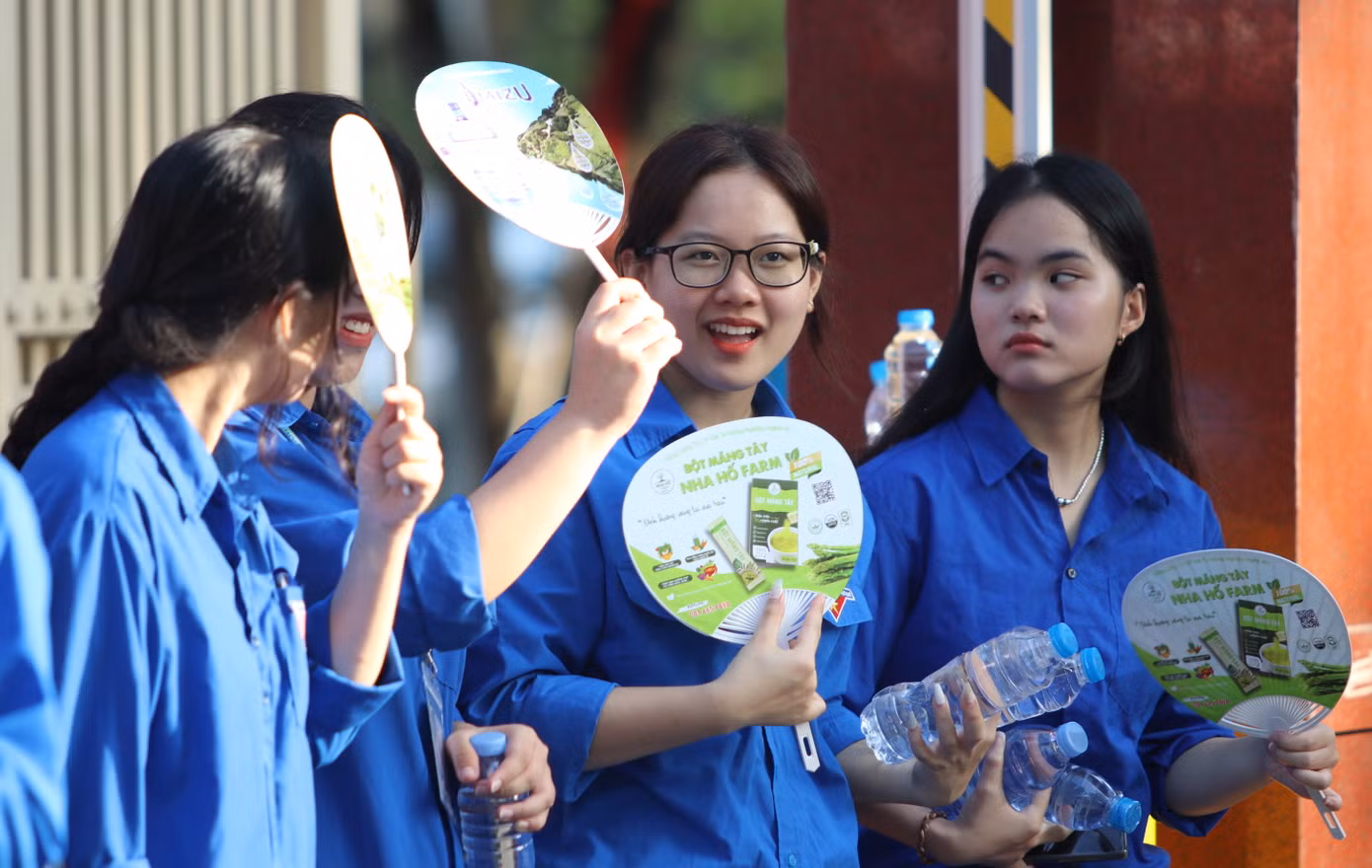 Những cô gái áo xanh trò chuyện trong lúc phát nước tiếp sức cho các sĩ tử ở điểm thi trường THPT chuyên Phan Bội Châu.