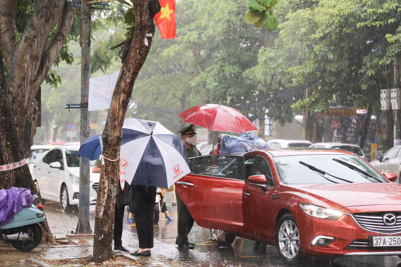 Thời tiết Nghệ An có mưa lớn, lực lượng đoàn viên của Đoàn công an tỉnh Nghệ An tiếp ứng thí sinh từ khi xuống xe. Trong ảnh: Đại úy Nguyễn Đình Khánh - Bí thư Đoàn công an tỉnh Nghệ An đón thí sinh vào điểm thi.