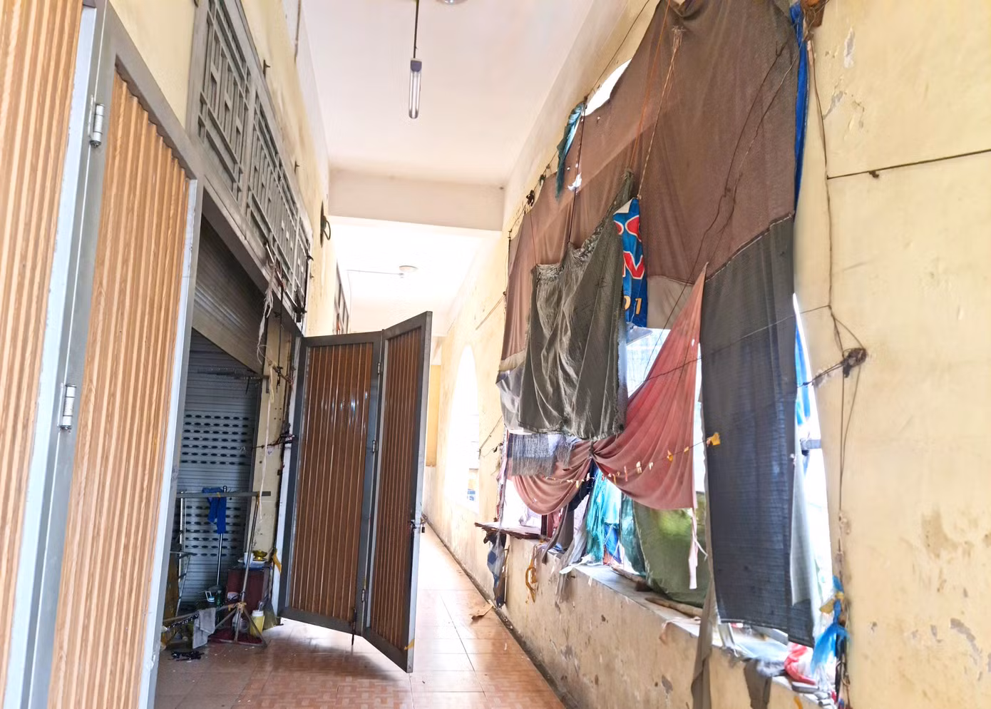 Dọc phía ngoài hành lang chợ, nhiều tiểu thương dùng vải, bạt che mưa che nắng tạo thành một khung cảnh nhếch nhác.