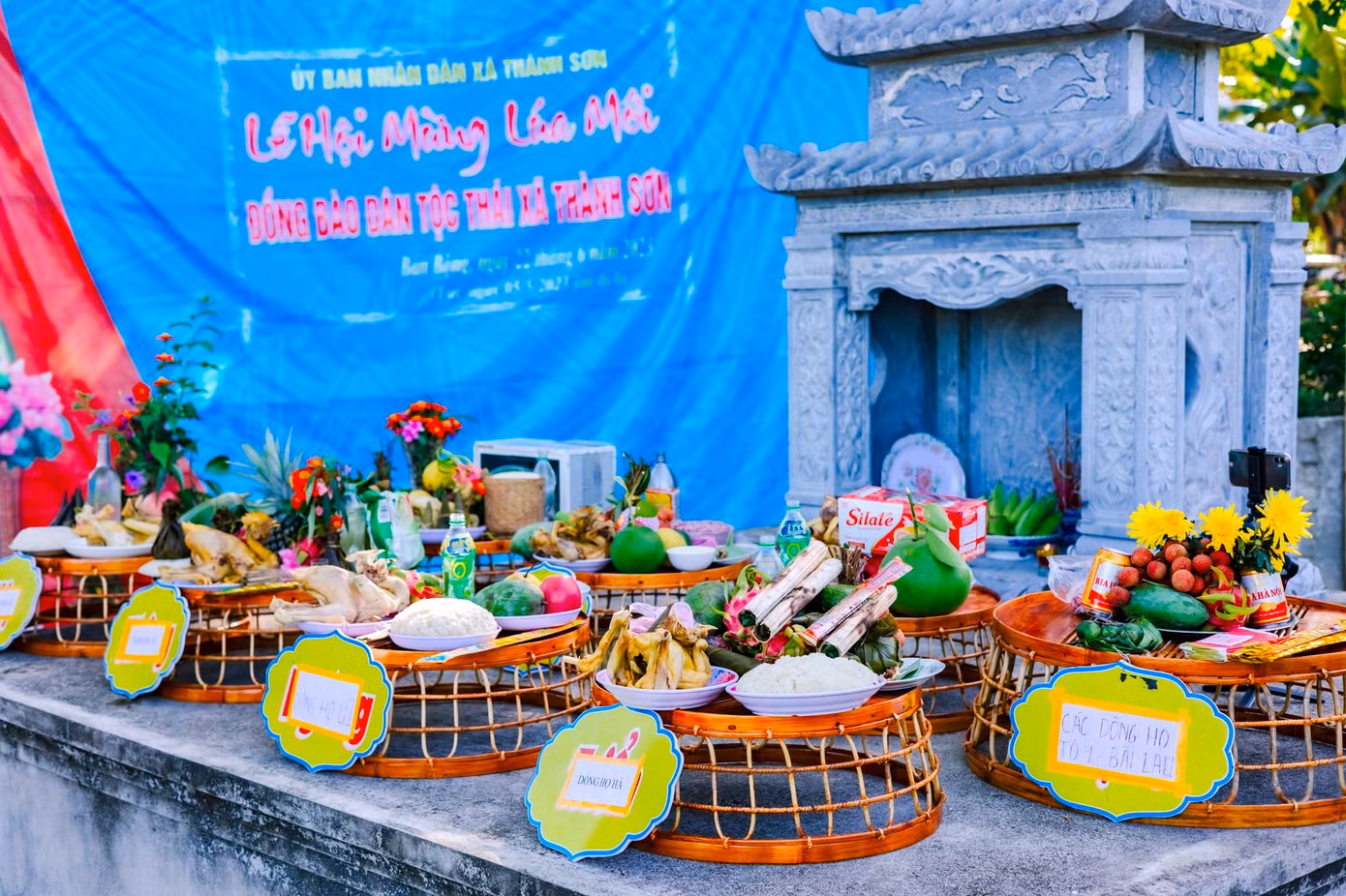 Để bắt đầu lễ hội, các dòng họ góp tiền làm mâm cơm cúng với những sản vật, sản phẩm do chính bà con dân bản làm ra từ hạt lúa, hạt gạo và các vật nuôi. Các dòng họ sau khi làm mâm cúng sẽ đưa ra nhà văn hóa cộng đồng để chuẩn bị lễ rước. Ảnh: Hạnh Phúc.