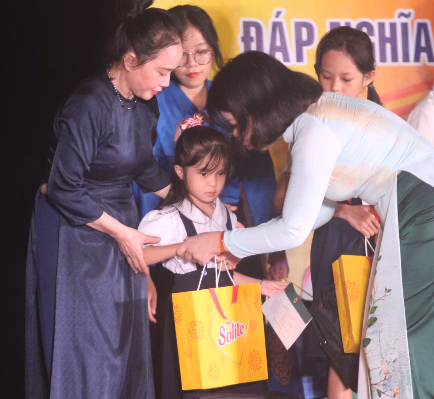 Bà Nguyễn Thị Lệ Trinh - Chủ tịch Hội Chữ thập Đỏ tỉnh Bình Dương (áo dài đen) và bà Nguyễn Thị Ngọc Xuân - Phó trưởng Đoàn đại biểu Quốc hội tỉnh Bình Dương tặng quà thiếu nhi là con, cháu của các Anh hùng liệt sĩ có hoàn cảnh khó khăn, nỗ lực học tập tốt.