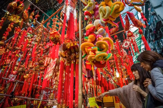 Hai cô gái Hồng Kông đang đi mua đồ trang trí tại một cửa hàng. Những hình con rắn xuất hiện rất nhiều ở các cửa hàng trong dịp này