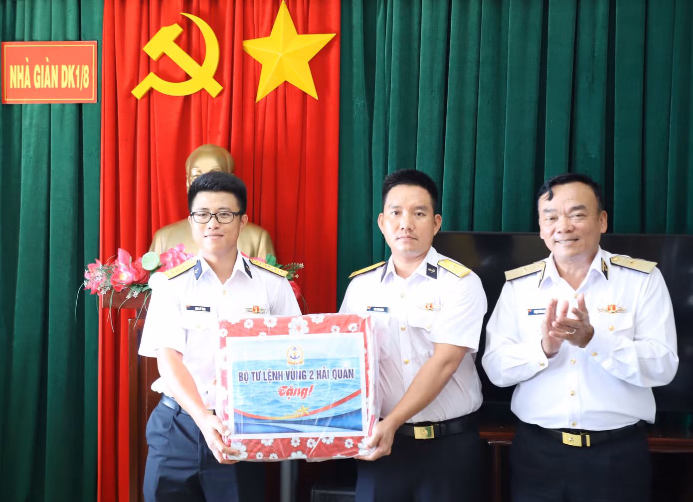 Đại úy Đinh Sỹ Tùng (trái) cùng chỉ huy đơn vị đón nhận món quà từ Chuẩn Đô đốc Phạm Văn Quang, Phó Chủ nhiệm Chính trị Quân chủng Hải quân.