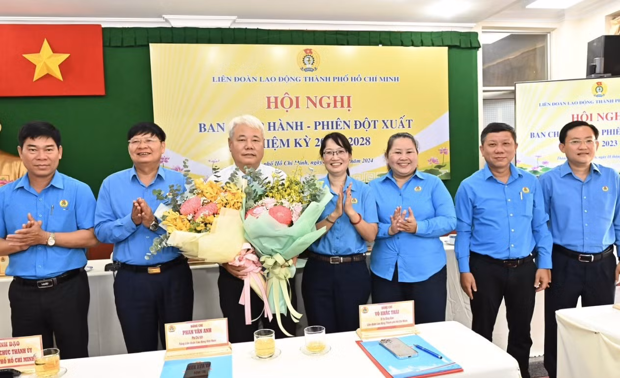 Bà Trần Thị Diệu Thúy (thứ 4 từ phải qua) - Phó Chủ tịch UBND TPHCM, nguyên Chủ tịch LĐLĐ TPHCM cùng các đại biểu tặng hoa chúc mừng ông Võ Khắc Thái. Ảnh: SGGP